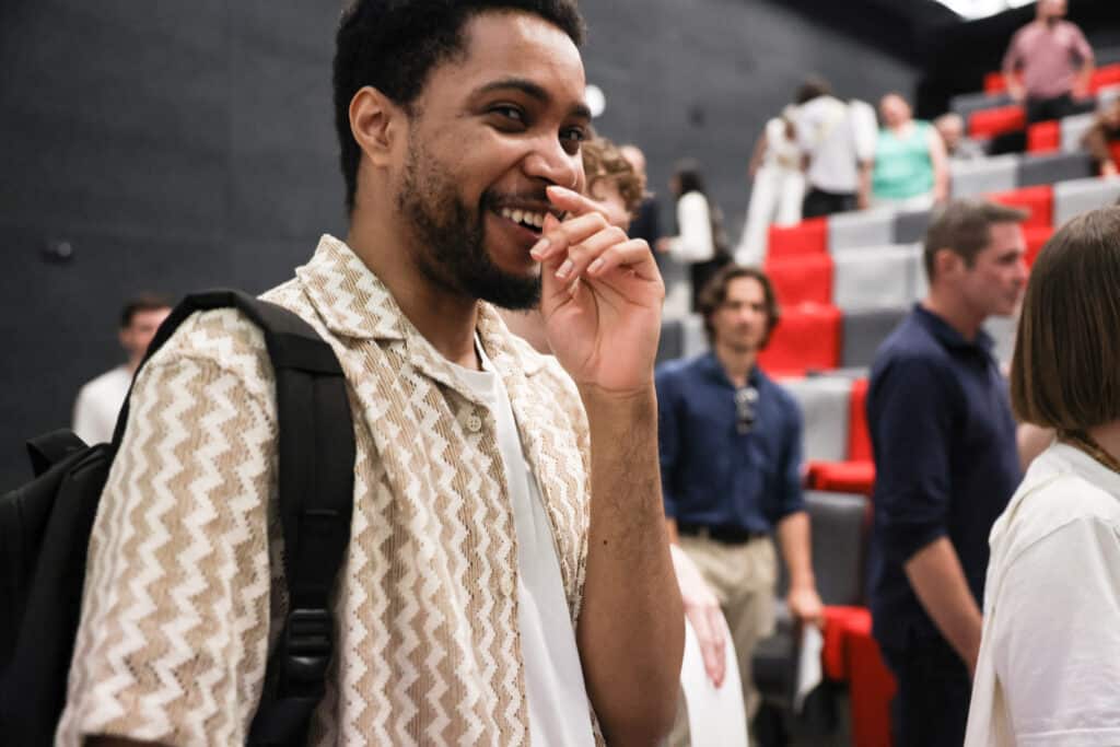 Étudiant de l’IFFDEC souriant à la fin d’un événement dans l’amphithéâtre de l’école.