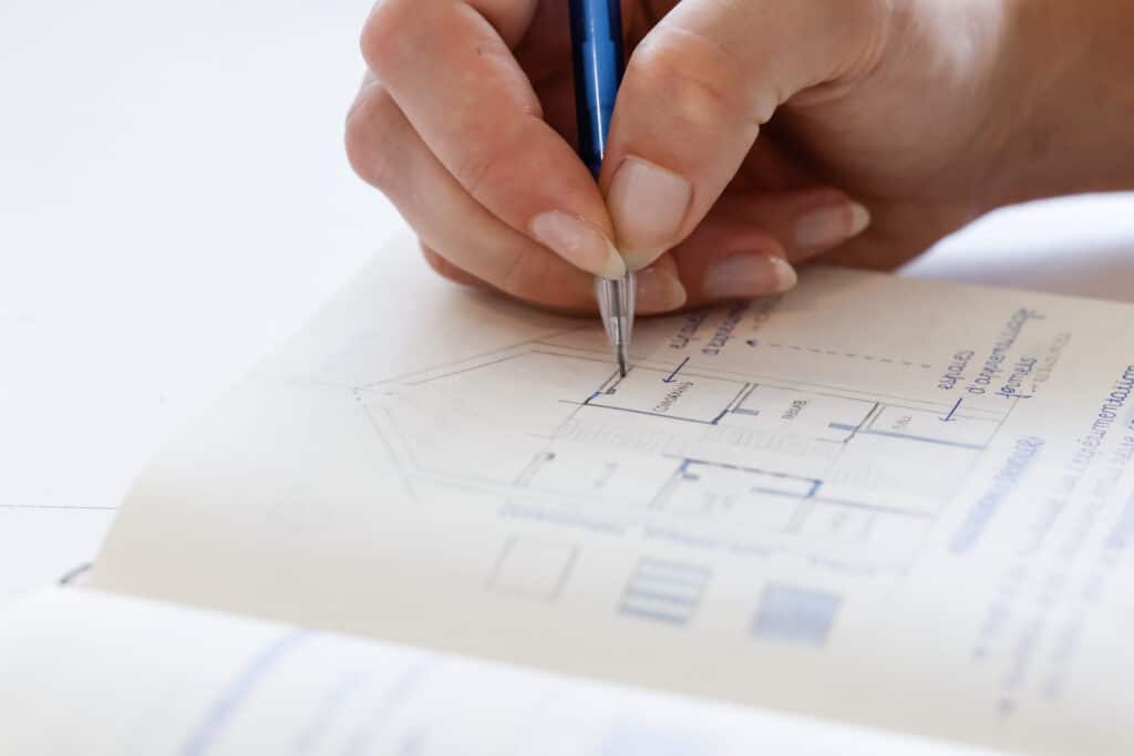 Main en train de dessiner un plan architectural dans un carnet à l’IFFDEC.