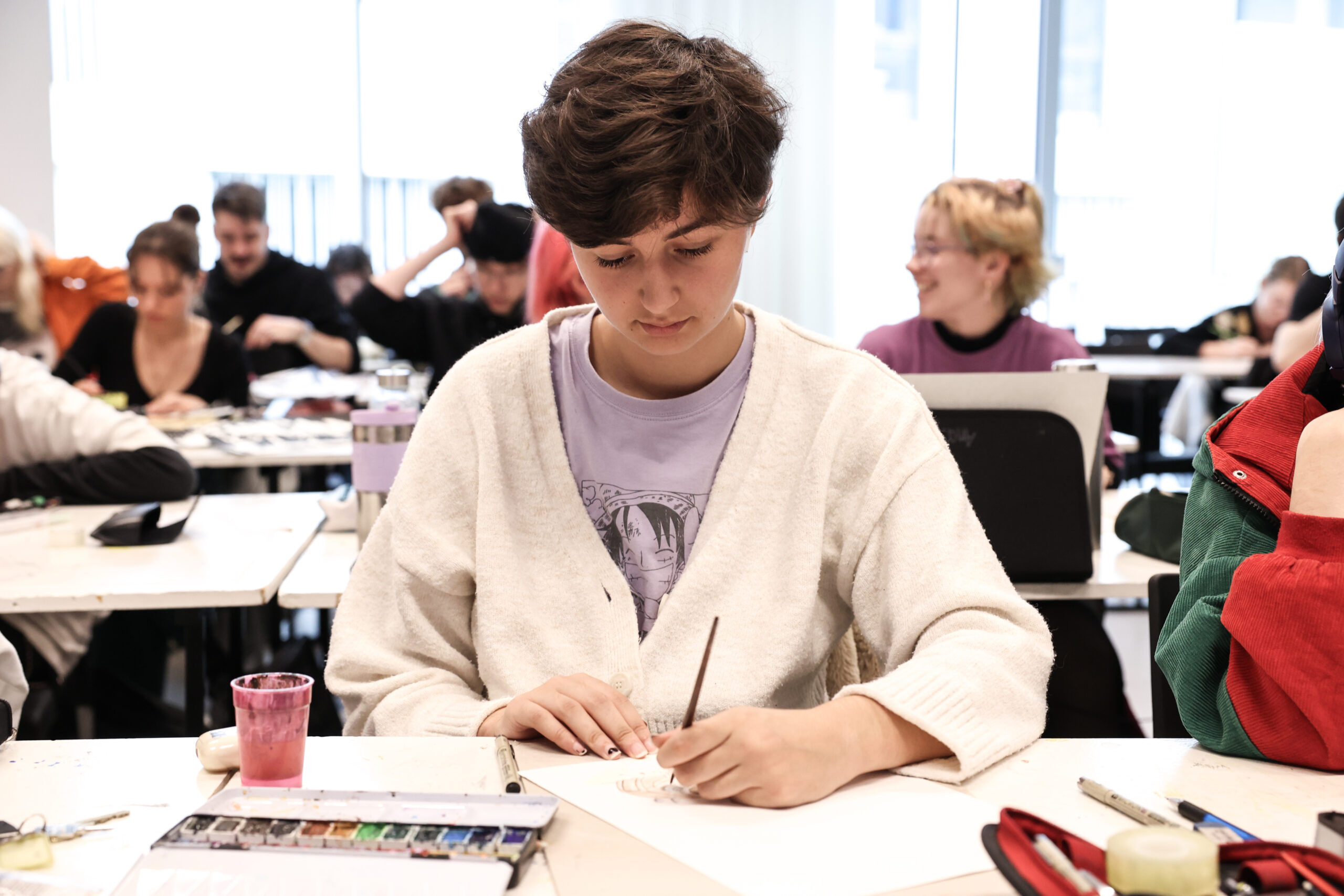 étudiante assise concentrée pull blanc