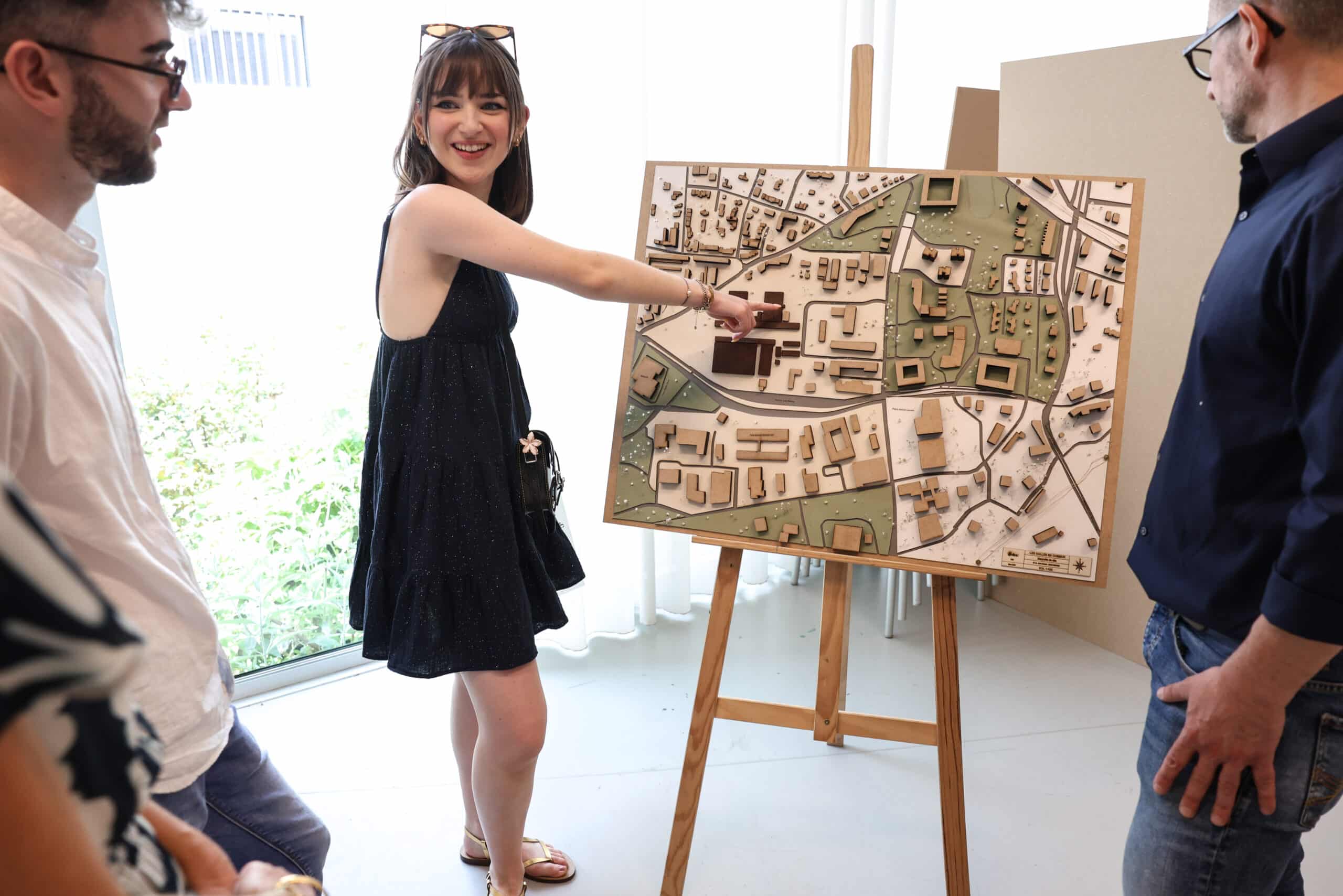 jeune femme devant un chevalet montrant un projet de design d'espace
