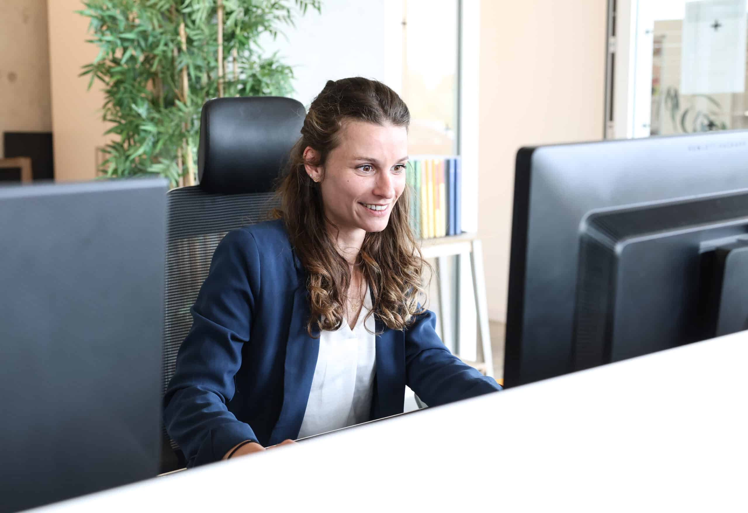 jeune femme souriant à son bureau